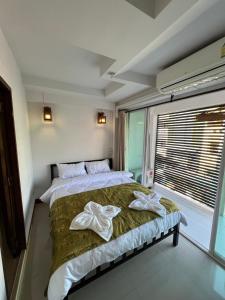 a bedroom with a bed with two towels on it at BB House Budget & Boutique in Chiang Mai