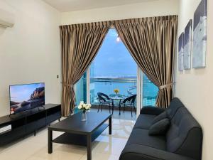 un soggiorno con un divano e una grande finestra di Paragon Suite Homestay by Antlerzone a Johor Bahru