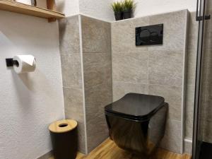 - un tabouret noir dans la salle de bains pourvue de toilettes dans l'établissement Landhaus Weindl, à Schönau am Königssee