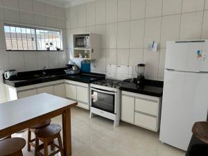 a kitchen with white appliances and a white refrigerator at Minha casa, sua casa in Porto Seguro