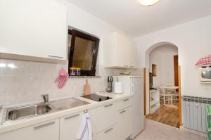 a kitchen with white cabinets and a sink at Apartments Bungavilia in Rovinj
