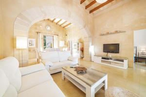 a living room with a white couch and a table at Villa Es Morer in Alcudia
