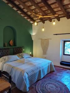 um quarto com uma cama grande e um edredão azul em Mas Del Llop Blanc - Dog friendly Hostal Rural - B&B em Sobrestany