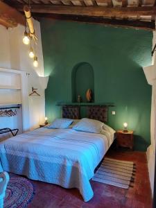 ein Schlafzimmer mit einem großen Bett in einer grünen Wand in der Unterkunft Mas Del Llop Blanc - Dog friendly Hostal Rural - B&B in Sobrestany