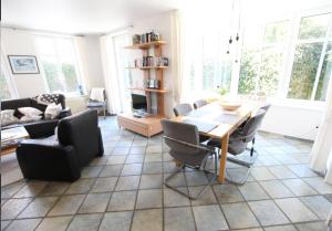a living room with a table and chairs at Karkpolder Residenz Haus 3 in Langeoog