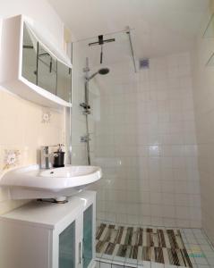 a white bathroom with a sink and a shower at Haus Silvia 