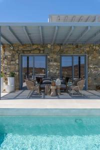 a patio with a table and chairs and a pool at Roca Bonita villa in Elia Beach