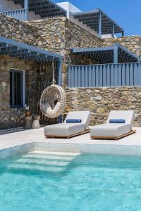 a swimming pool with two lounge chairs next to a building at Roca Bonita villa in Elia Beach