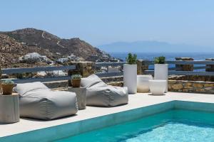 a pool with chaise lounge chairs next to the ocean at Roca Bonita villa in Elia Beach