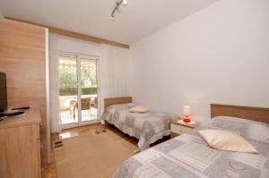 a hotel room with two beds and a balcony at Apartments Bungavilia in Rovinj