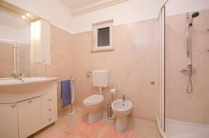 a bathroom with a toilet and a sink and a shower at Apartments Bungavilia in Rovinj +20 photos