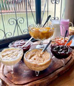 uma mesa com diferentes tipos de sobremesas em taças em Pouso das Flores -350m Maria Fumaça em Tiradentes