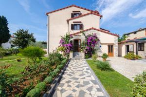a house with a garden in front of it at Apartments Bungavilia in Rovinj