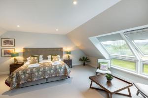 1 dormitorio con cama y ventana grande en Greenmyre Farmhouse with Hot Tub en Kirriemuir