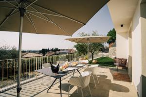 a patio with a table and chairs and an umbrella at Cavalino Boutiquehouse in Cavaion Veronese