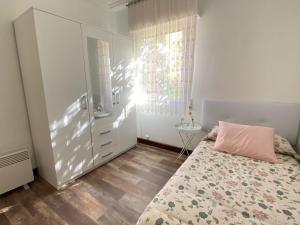 um quarto com uma cama com uma almofada cor-de-rosa em Bajo con terraza a 5 min de la playa (3 hab-6 per) em Santander