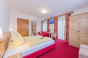 1 dormitorio con 1 cama grande y alfombra roja en Hotel - Pension Ötzmooshof en Sankt Johann im Pongau