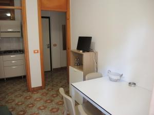 Zimmer mit einem Tisch und einer Küche mit einem TV in der Unterkunft Spacious and bright flat near the beach - Beahost in Bibione