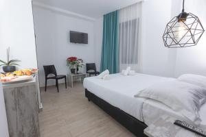 1 dormitorio blanco con 1 cama, mesa y sillas en Evita Asty en Atenas