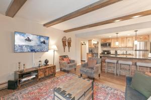 a living room with a couch and chairs and a kitchen at Trails End Condo in Breckenridge