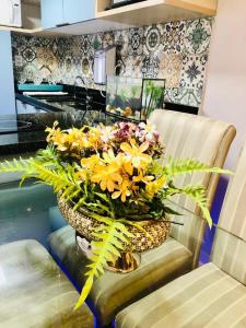 a vase filled with yellow flowers sitting on a chair at apart hotel 2 quartos frente mar in Salvador
