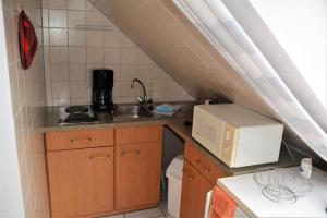 a small kitchen with a sink and a microwave at Haus Dorenbusch Haus am Kap, Whg 02 links in Norderney