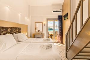 um quarto de hotel com duas camas e uma escada em Kalogria em Stoupa