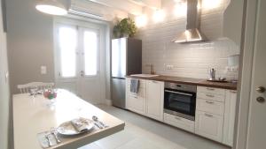 una cucina bianca con lavandino e piano cottura di Marietta's House a Città di Rodi