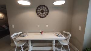 a dining room table with chairs and a clock on the wall at Marietta's House in Rhodes Town