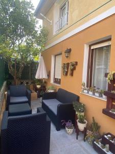 een patio met 2 banken en potplanten naast een gebouw bij Bajo con terraza a 5 min de la playa (3 hab-6 per) in Santander
