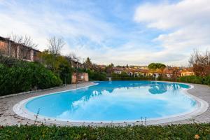 una gran piscina azul en un patio en Casa Esmeralda, en Polpenazze del Garda