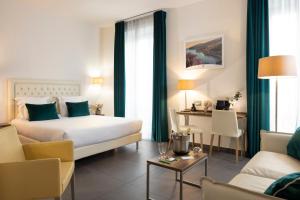 a hotel room with a bed and a living room at Hôtel Nice Azur Riviera in Nice