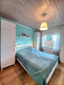 a bedroom with a blue bed and a window at Apfelhaus beim Hennesee in Meschede