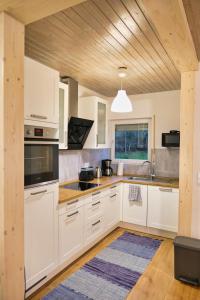 cocina con armarios blancos y techo de madera en Apfelhaus beim Hennesee, en Meschede