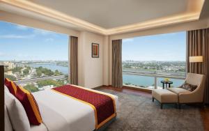 a hotel room with a bed and a large window at Hyatt Regency Ahmedabad in Ahmedabad