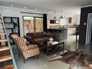 sala de estar con sofá, sillas y mesa en Panorama Guest House en Johannesburgo