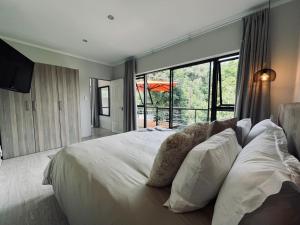 a bedroom with a large white bed with a large window at Panorama Guest House in Johannesburg
