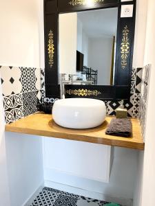 bagno con lavandino bianco e specchio di SalutBB Chambre d'hote a Carcassonne
