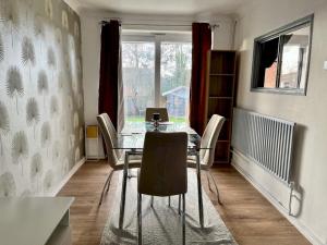 een eetkamer met een tafel met stoelen en een laptop bij Pass the Keys Stylish Family Friendly 3 Bed home with Parking in Bushey