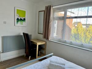 sypialnia z biurkiem, oknem i łóżkiem w obiekcie Pass the Keys Stylish Family Friendly 3 Bed home with Parking w mieście Bushey