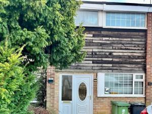 a brick house with a blue door and trees at Pass the Keys Stylish Family Friendly 3 Bed home with Parking in Bushey