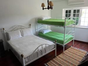 een slaapkamer met 2 stapelbedden met een groene matras bij Solar das Mimosas 2 casas in Sintra