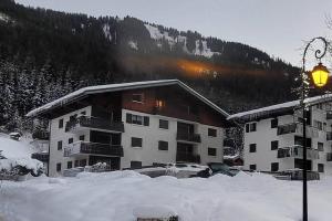 a large building with snow in front of a mountain at Studio Châtel rénové et lumineux in Châtel