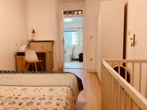 a bedroom with a bed and a desk and a staircase at Nice rooms in Beggen house - In Luxembourg city in Luxembourg