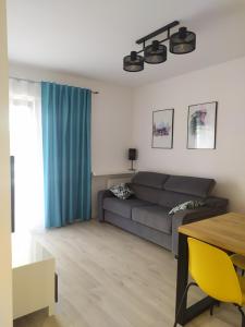 a living room with a couch and a table at Apartament FOCUS DUO in Gdańsk