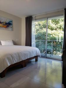 a bedroom with a bed and a large window at Hotel CaLu 2 en La Laguna, Santa María del Oro in Santa María del Oro