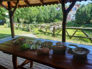 a wooden table with bowls of food on it at Gospodarstwo Agroturystyczne Pod Lasem Maria Płazio in Narol