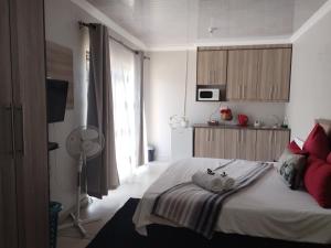 um quarto com uma cama grande e almofadas vermelhas em Tokelo Guesthouse Emalahleni em Witbank