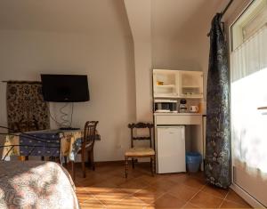 a room with a table and a television and a desk at Tra Gli Ulivi in Pietra Ligure