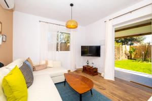 Casa Flor في زاهورا: غرفة معيشة مع أريكة بيضاء وتلفزيون